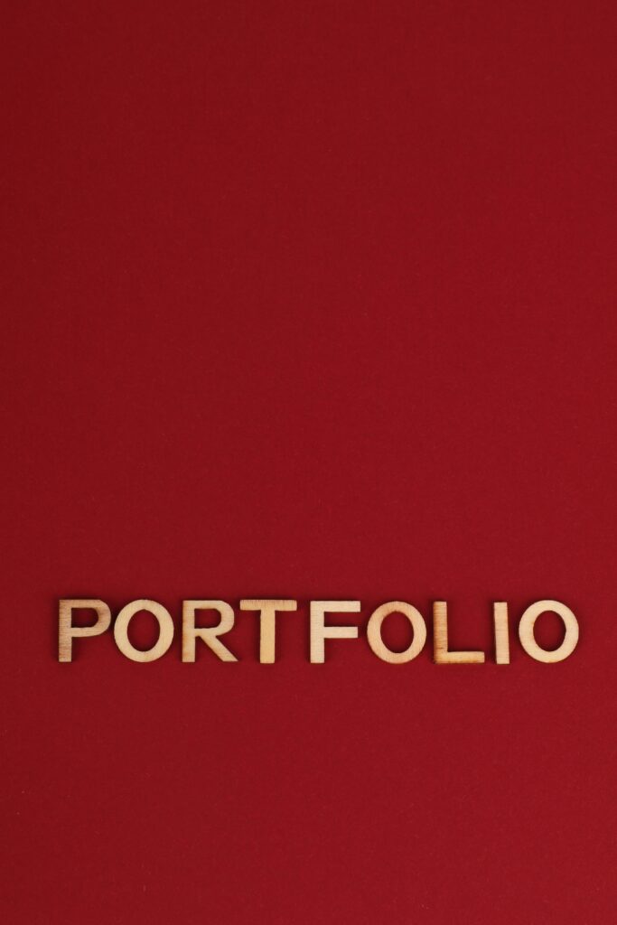Wooden text spelling 'PORTFOLIO' on a bold red background, ideal for design and business themes.